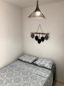 a bedroom with a bed and a hanging light at Beira Mar Residencial in Guaibim