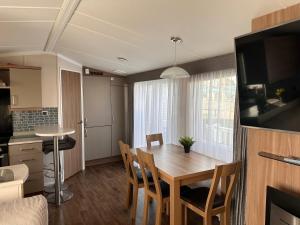 uma cozinha e sala de jantar com mesa e cadeiras em Ranworth - Haven Holiday Park em Caister-on-Sea