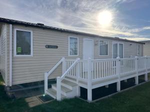 Ce mobile home dispose d'une terrasse couverte blanche et d'escaliers. dans l'établissement Ranworth - Haven Holiday Park, à Caister-on-Sea