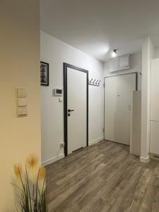 une chambre vide avec deux portes blanches et du parquet dans l'établissement Apartament Chiara, à Oleśnica
