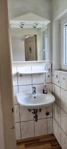 y baño con lavabo blanco y espejo. en Monterwohnungen Santos-Lerch, en Viersen