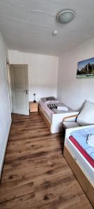two beds in a room with wooden floors at Monterwohnungen Santos-Lerch in Viersen