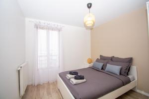 um quarto com uma cama com duas toalhas em 2 pièces Vitry rénové avec balcon (15 min Paris) em Vitry-sur-Seine