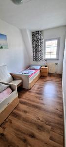 1 dormitorio con 2 camas y suelo de madera en Monterwohnungen Santos-Lerch, en Viersen