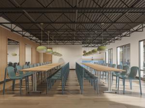 une salle de conférence avec des tables en bois et des chaises vertes dans l'établissement LOGE Missoula, à Missoula