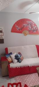 a bed in a room with a red umbrella on the wall at Apartamento Tá Querendo Praia! in Guarujá