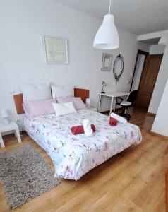 un dormitorio con una cama con dos animales de peluche en El Rincón del Pisuerga con Terraza, en Cabezón de Pisuerga