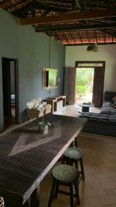 Village por do sol في أراكاجو: غرفة معيشة مع طاولة وكراسي كبيرة