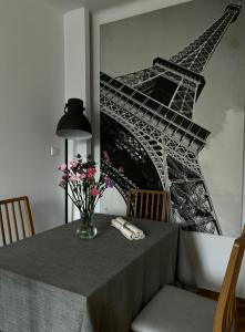 a table with a vase of flowers and the eiffel tower at Apartament K3 in Warsaw