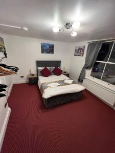 a bedroom with a bed and a red carpet at HELIN’s Cottage in Whitby