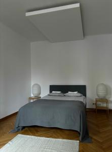 a white bedroom with a bed with two lamps at Apartament K3 in Warsaw