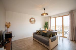 uma sala de estar com um sofá e uma mesa em 2 pièces Vitry rénové avec balcon (15 min Paris) em Vitry-sur-Seine