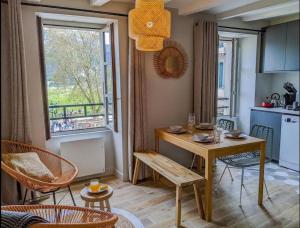 uma cozinha e sala de estar com mesa e cadeiras em La Perle du Lac 3* - VUE LAC em Annecy