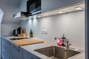 cocina con fregadero y encimera en Moonshine Apartment - Altstadtflair in der City mit Parkplatz und Home Office en Brunswick