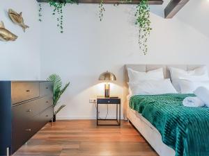 1 dormitorio con 1 cama con manta verde en Moonshine Apartment - Altstadtflair in der City mit Parkplatz und Home Office en Brunswick