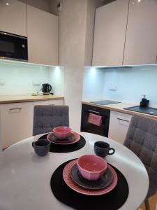 a kitchen with a table with two bowls on it at Premium Spire Apartment +parking in Warsaw