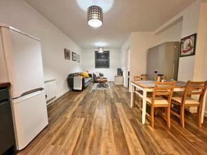 a kitchen and living room with a table and a refrigerator at Town Centre Apartment, 4 Beds, 1 Bathroom in Cheltenham