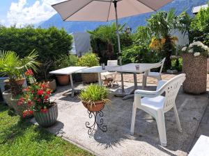 eine Terrasse mit einem Tisch, Stühlen und einem Sonnenschirm in der Unterkunft Bristenblick in Fluelen