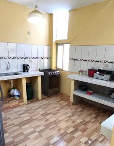 a large kitchen with white cabinets and a stove at Departamento de Pablito Junto al Mar in Caleta Cruz