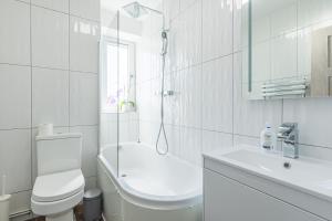 Baño blanco con aseo y lavamanos en Charming 1 Bedroom Serviced Apartment in Camden, en Londres