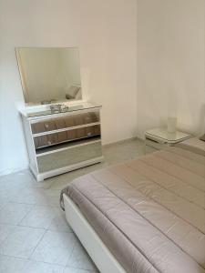 a bedroom with a dresser with a mirror and a bed at Orchidea House in Serravalle Scrivia +9 photos