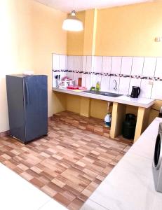 a kitchen with a refrigerator in the middle of a room at Departamento de Pablito Junto al Mar in Caleta Cruz