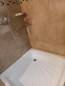 um chuveiro com uma banheira branca na casa de banho em Cabañas Los Nonos em El Bolsón