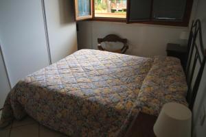 a bedroom with a bed with a quilt on it at Appartamenti Pian d'Alma in Punta Ala
