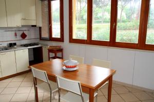 a kitchen with a wooden table and chairs in it at Appartamenti Pian d'Alma in Punta Ala