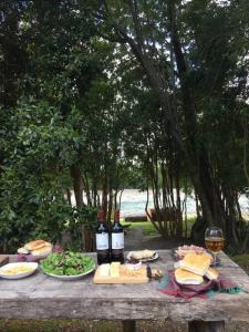 een picknicktafel met twee flessen wijn en eten bij Casa Murta in Chaitén