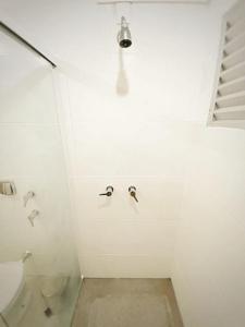 105 Saint Sebastian Flat في جاراغوا دو سول: حمام ابيض مع مرحاض واضاءة