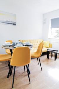 uma sala de jantar com uma mesa e cadeiras e um sofá em 5 bed house with driveway! em Luton