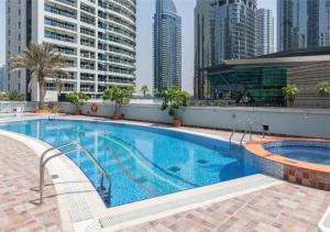 a swimming pool on the roof of a building with tall buildings at Astonishing 1 Bedroom in Jumeirah Lake Towers in Dubai