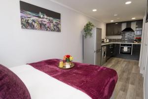 a kitchen with a white bed with a purple blanket at Dane Duplex Studio Seven - Your Dream Coventry Stay in Coventry