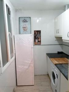 a white kitchen with a refrigerator in a room at Sebastian Elcano, apartamento para 2 con terraza, metro Embajadores in Madrid