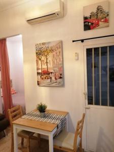 a table and chairs in a living room with a painting at Sebastian Elcano, apartamento para 2 con terraza, metro Embajadores in Madrid