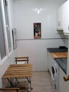 a kitchen with a bench and a table and a washing machine at Sebastian Elcano, apartamento para 2 con terraza, metro Embajadores in Madrid