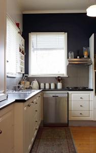 a kitchen with white cabinets and a sink and a window at Borough Country House in Korumburra +22 photos