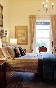 a bedroom with a large bed and a window at Borough Country House in Korumburra