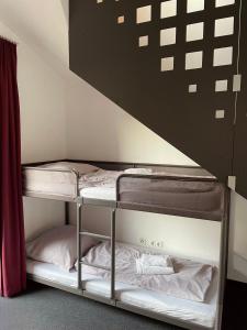 a bunk bed with two bunk beds in a room at Hotel Caldor - 24h self-check in in Münchendorf