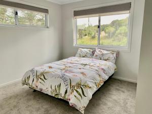 een slaapkamer met een bed en 2 ramen bij Elevate Escape in Venus Bay