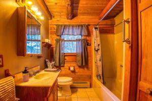 baño con lavabo y aseo y ventana en Family-Focused & Pet-Friendly Log Cabin with 4BR 2BA Sleeps 10, en Bethlehem