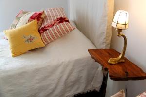 1 dormitorio con 1 cama con lámpara y almohadas en Casa Toníca, en Crato