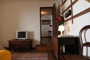 Habitación con escritorio y mesa con TV. en Casa Toníca, en Crato