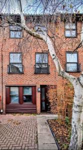 a brick building with a tree in front of it at Quiet 4 Bedroom House between Camden & Kings Cross in London