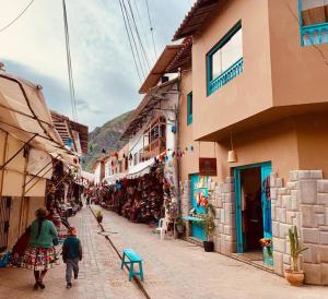 a couple of people walking down a street with buildings at Departamento acogedor céntrico en Pisac in Pisac
