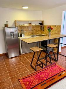 a kitchen with a table and a stainless steel refrigerator at Departamento acogedor céntrico en Pisac in Pisac +6 photos