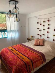 - une chambre avec un lit et une couverture colorée dans l'établissement Departamento acogedor céntrico, à Cusco