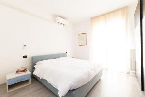 een witte slaapkamer met een bed en een raam bij Oasi 2bedr vicino Groane/Rho Fiera/Milano/MXP in Cesate