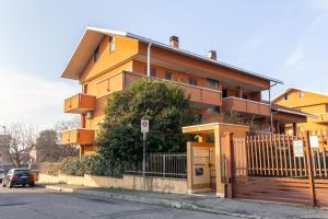 un grand bâtiment jaune avec une clôture devant lui dans l'établissement Oasi 2bedr vicino Groane/Rho Fiera/Milano/MXP, à Cesate